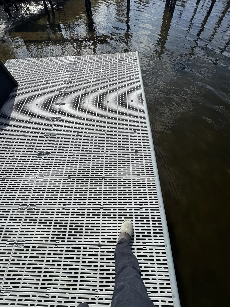 A close view of grated dock decking beside the water