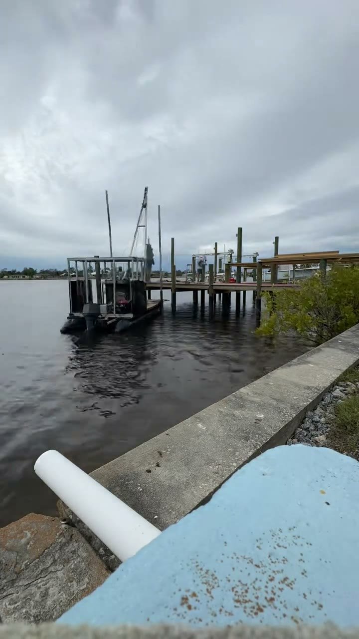 Marine work barge beside timber waterfront pilings