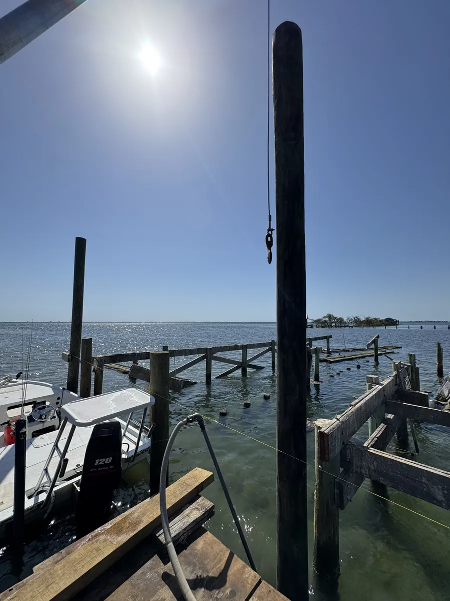 Tall timber pilings, waterfront framing and a work boat beside open water
