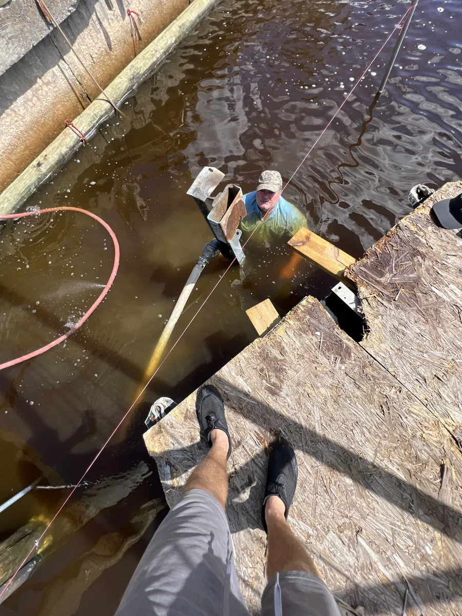 Marine crew member working beside timber waterfront framing
